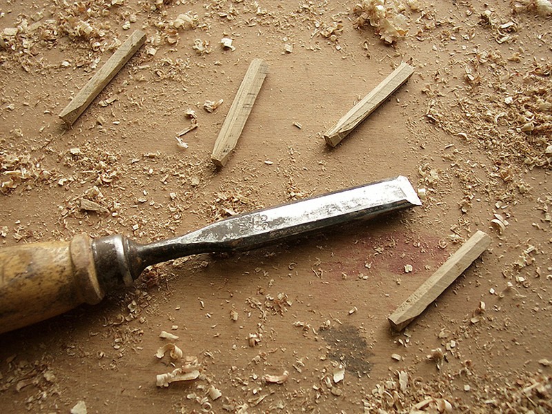 Stecheisen und handgefertigte Holznägel auf der Werkbank
